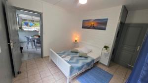 a small bedroom with a bed and a table at Villa El Gato in Bouillante