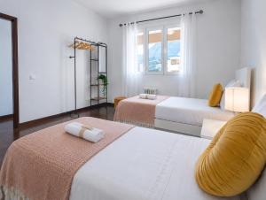 a white room with two beds and a mirror at Villa Herédia - 5 min form the beach in Ribeira Brava