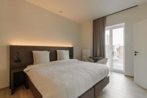 a bedroom with a large bed and a sliding glass door at Manteka Logies in Ieper