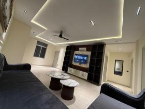 a living room with a couch and a tv at Janjua lodges Murree in Murree