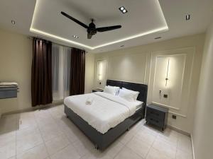a bedroom with a bed with a ceiling fan at Janjua lodges Murree in Murree