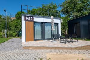 a building with chairs and an umbrella in front of it at Ubytovanie Pod Farou Bojnice in Bojnice
