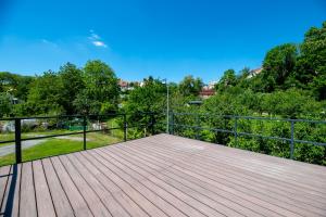 a large wooden deck with a black railing at Ubytovanie Pod Farou Bojnice in Bojnice