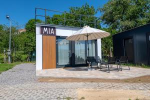 a building with a table and chairs and an umbrella at Ubytovanie Pod Farou Bojnice in Bojnice