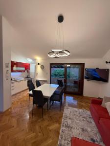 a dining room and kitchen with a table and chairs at Apartmani Antea in Preko
