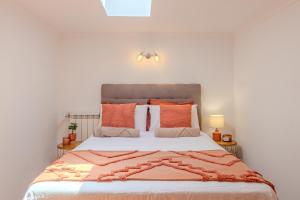 a bedroom with a large bed with orange pillows at Ocean View Luxury Duplex Apartment in Ovar