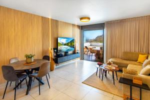 a living room with a couch and a table and a television at מגדליה סוויט - סויטה למשפחות עם בריכת זרמים וגקוזי פרטיים in Migdal