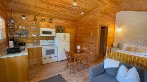 a kitchen and living room in a log cabin at Lawrencetown Lodge - The Maple Studio in Three Fathom Harbour