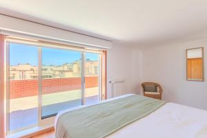 a bedroom with a bed and a large window at Ocean View Luxury Duplex Apartment in Ovar
