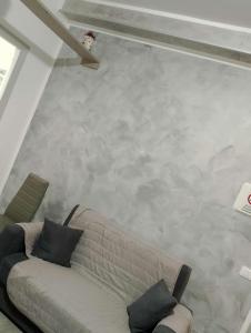 a living room with a couch and a concrete wall at LA casetta 2.0 in Termini Imerese +1 photo