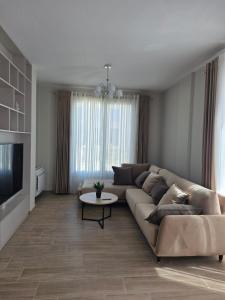 a living room with a couch and a table at Villa Gala - First Floor Apartment in Draç