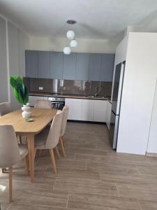 a kitchen with a wooden table and a refrigerator at Villa Gala - First Floor Apartment in Draç +9 photos