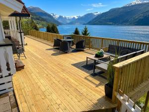 a deck with a view of a lake and mountains at Faleide Panorama Private Fjord View Cabin with Large Terrace in Stryn