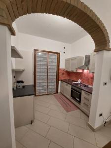a large kitchen with an archway in a house at Agriturismo La Fine in Piancaldoli +14 photos