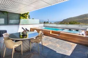 a patio with a table and chairs and a swimming pool at מגדליה סוויט - סויטה למשפחות עם בריכת זרמים וגקוזי פרטיים in Migdal