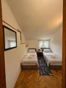 a room with three beds and a mirror at Apartmani Antea in Preko