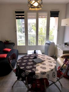 a living room with a table and a couch at Appartement moderne climatisé in Nyons