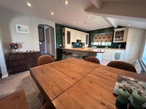 a large kitchen with a wooden table and chairs at Eagle Cottage in Penrith