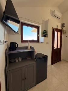 a kitchen with a stove and a sink and a window at Apartmani Antea in Preko +17 photos