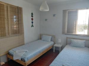a bedroom with two twin beds and a window at Ria de Aveiro White House in Murtosa