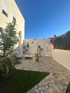 a courtyard of a house with a bench and grass at Green Oasis in Bou Ficha