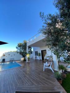 a villa with a swimming pool and a patio at Green Oasis in Bou Ficha