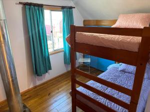 a bedroom with two bunk beds and a window at Casa Mañío Hostal Castro in Castro