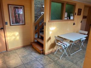 a table and chairs in a room with a staircase at Casa Mañío Hostal Castro in Castro