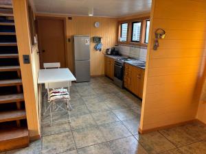 a kitchen with a white table and a refrigerator at Casa Mañío Hostal Castro in Castro +11 photos