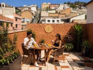 a man and woman sitting at a table on a patio at Hotel Mediterraneo Quito in Quito +28 photos