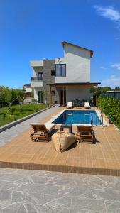 a swimming pool with two chairs and a house at Julis Villa in Draç
