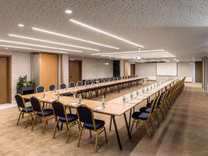 a large conference room with long tables and chairs at Mercure Tirana in Tirana +106 photos
