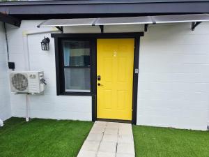 a yellow door on the side of a house at Lovely Single Apartment in Tampa