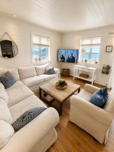 a living room with two couches and a table at The Reine Scenic View in Moskenes