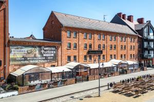 ein Backsteingebäude mit einem Bahnhof davor in der Unterkunft Hotel Bulwar Ustka in Ustka