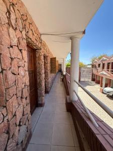 a building with a stone wall and a balcony at complejo laprida in Santa Lucía