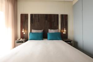 a bedroom with a large white bed with blue pillows at YMY Beach House in Agadir