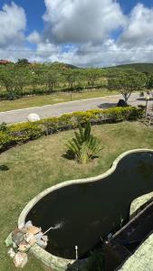 a pool of water in the middle of a yard at Flat em Gravatá - Villa Monte Castelo in Sairé