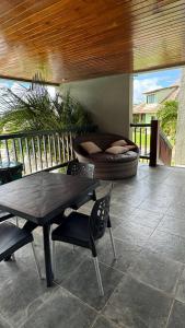 a patio with a table and chairs and a couch at Flat em Gravatá - Villa Monte Castelo in Sairé