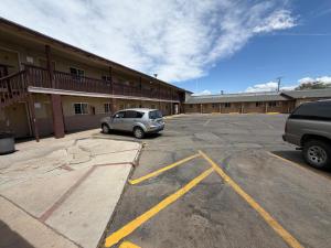 a car parked in a parking lot in front of a building at Encore Motel in Farmington +8 photos