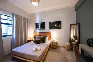 a bedroom with a bed with two lamps and a window at Casa Origen in Oaxaca City