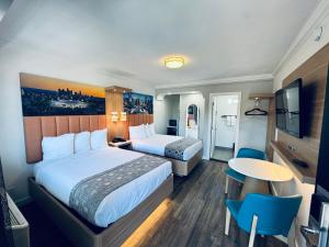 a hotel room with two beds and a table at The Lexmar - Dodger Stadium-Convention Center in Los Angeles