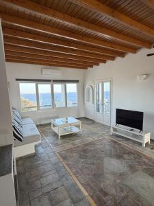 a living room with a couch and a tv at The Aegean Horizon Villa in Grótta
