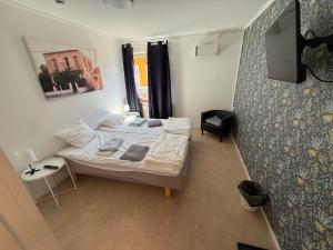 a small bedroom with a bed and a television at Bakgården Mariestad in Mariestad