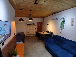 a living room with a blue couch and a table at Apartamento em juquehy in São Sebastião