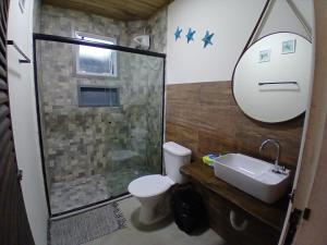 a bathroom with a shower and a toilet and a sink at Apartamento em juquehy in São Sebastião