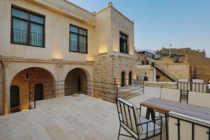 a patio with a table and chairs and a building at Mezova Otel in Mardin