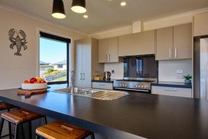 a large kitchen with a large counter top with a sink at Spacious, Family-Friendly, Parkside - KK67479 in Kaikoura