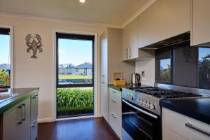 a kitchen with a stove top oven next to a window at Spacious, Family-Friendly, Parkside - KK67479 in Kaikoura