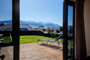 a sliding glass door with a bench on a deck at Spacious, Family-Friendly, Parkside - KK67479 in Kaikoura